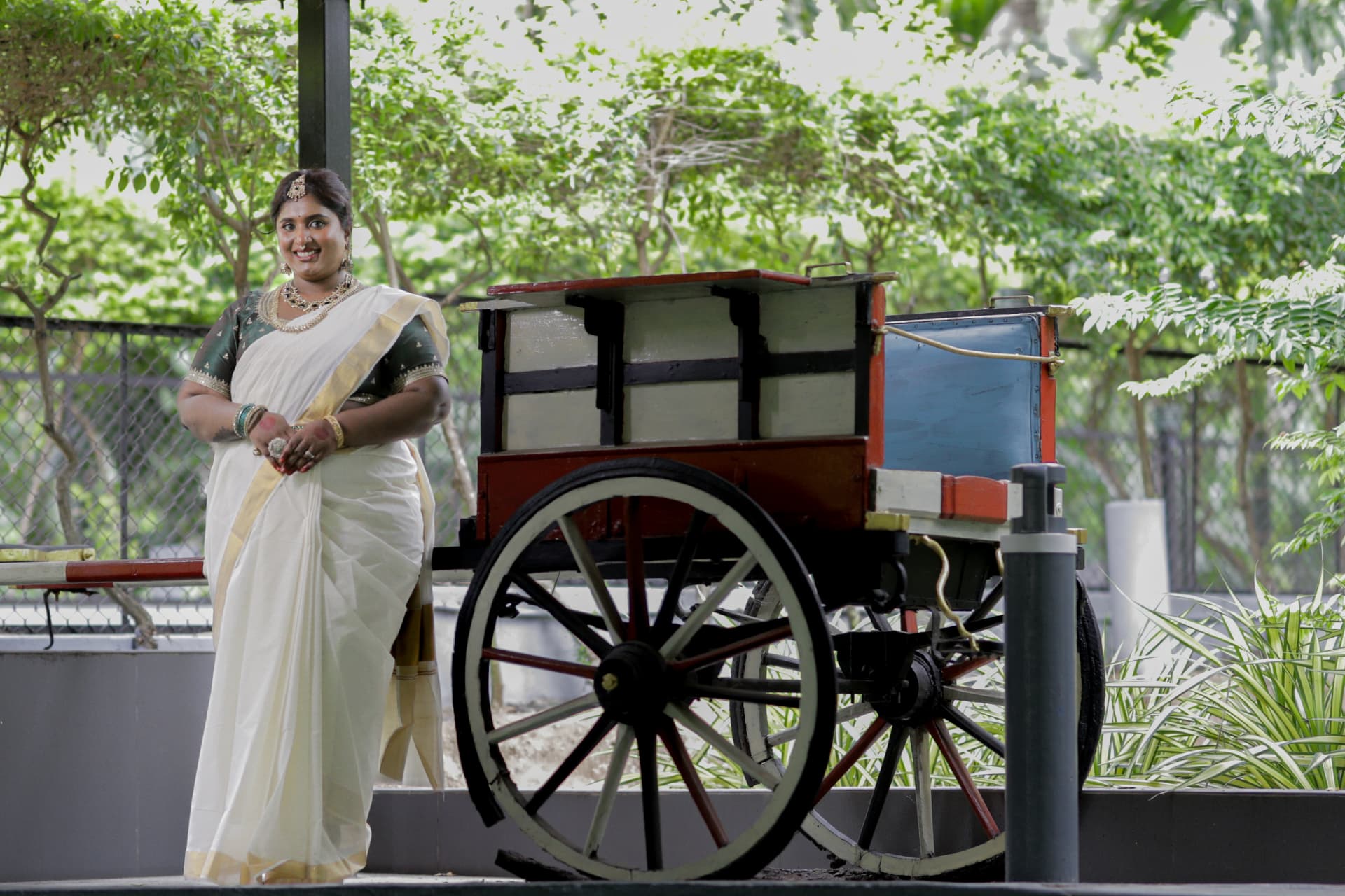 Dr. Ashvini Sundararaju leaning against a traditional wooden cart