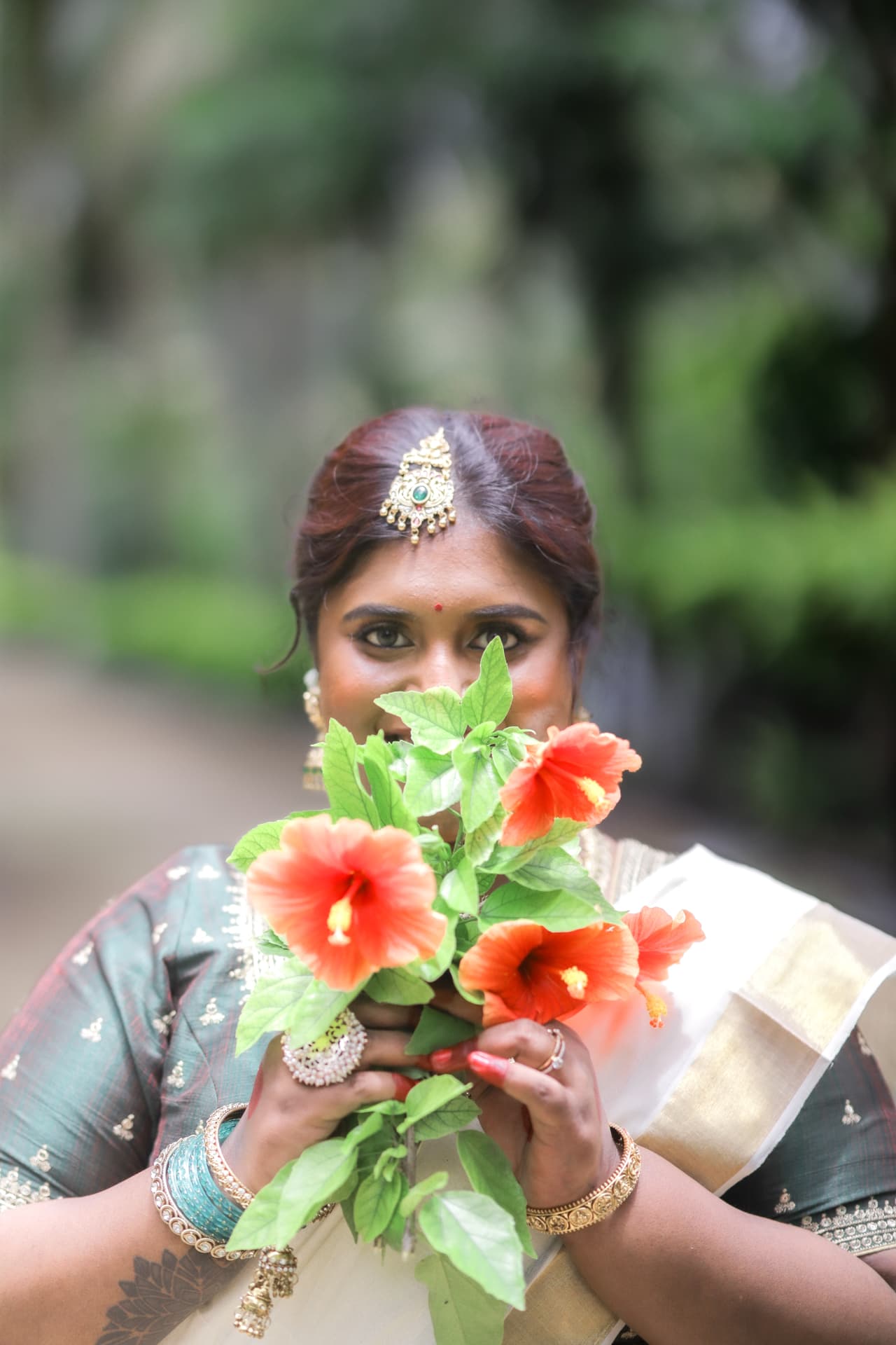 Dr. Ashvini Sundararaju holding red hibiscus flowers