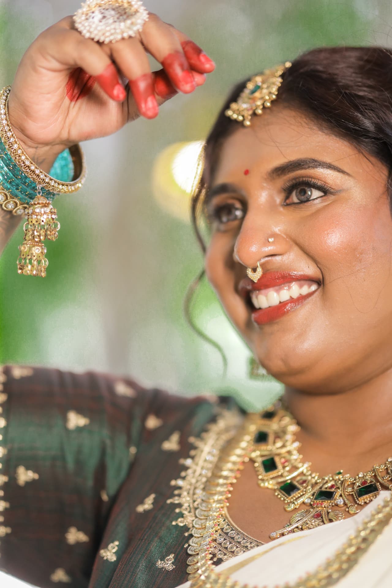 Close-up of Dr. Ashvini Sundararaju smiling, hand near her jhumka earring