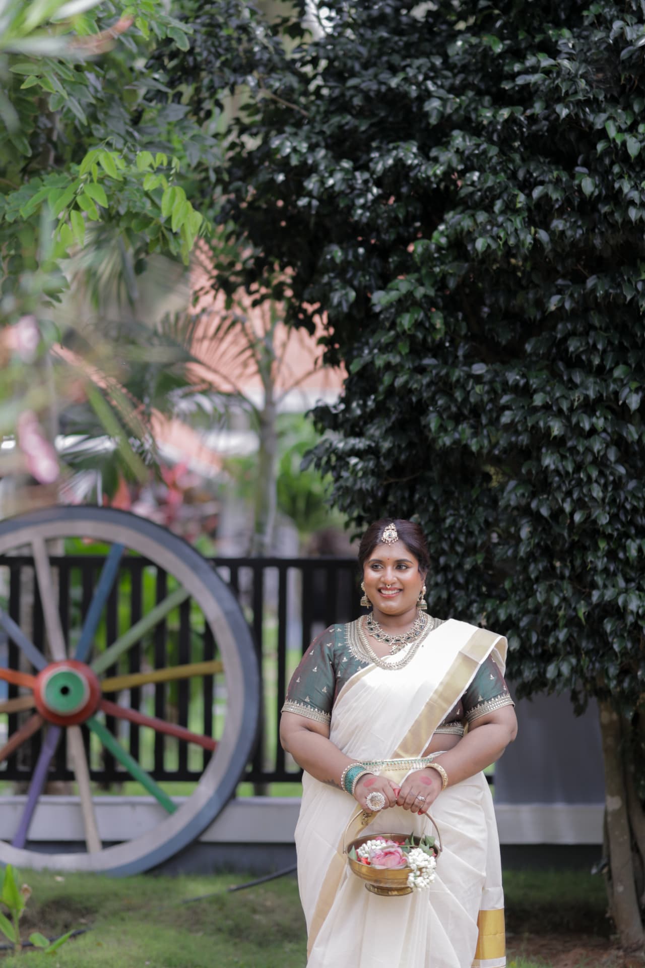 Dr. Ashvini Sundararaju in a Kasavu saree holding a basket of flowers