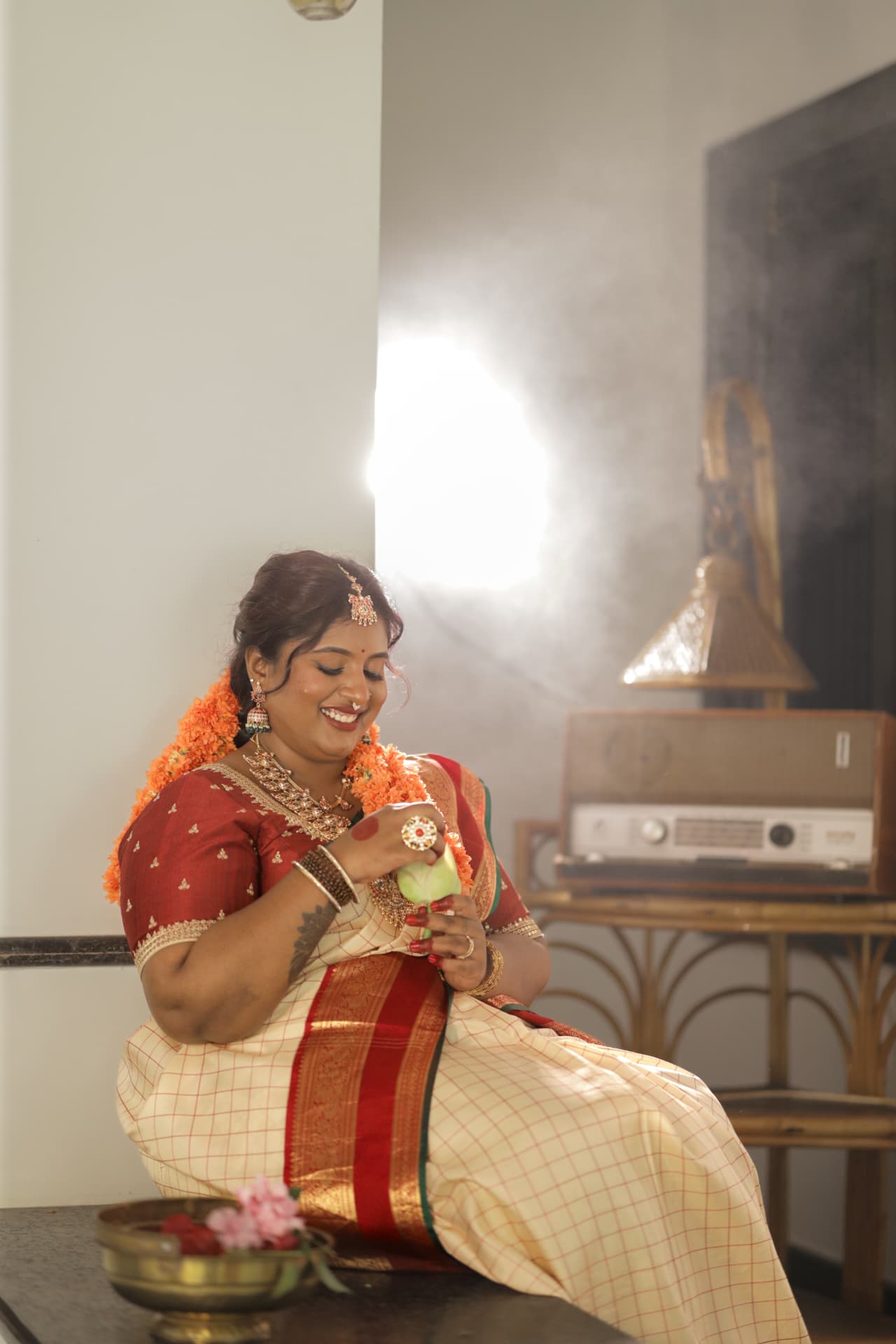 Dr. Ashvini Sundararaju seated with a lotus beside a vintage radio