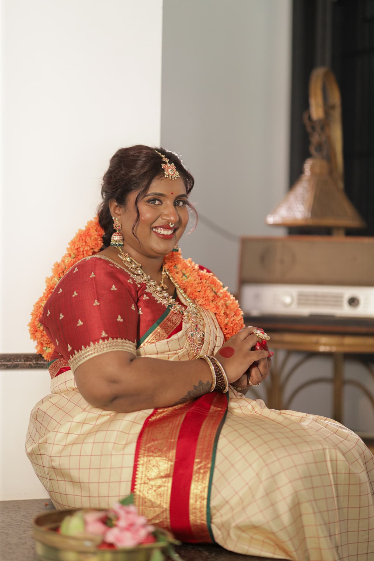 Dr. Ashvini Sundararaju smiling beside a vintage radio